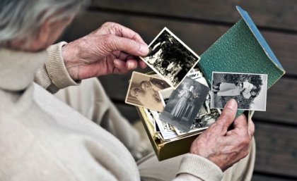 Image: Adobe Elderly woman holding old photographs. Adobe.
